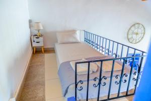 a small bedroom with a bed and a clock on the wall at Kali Strata 2 - Downtown in Symi