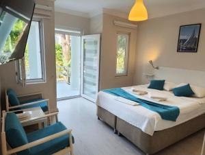 a bedroom with a large bed with blue pillows at Göcek Selya Hotel in Göcek +34 photos