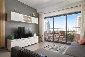 a living room with a tv and a large window at Portimão, Praia da Rocha in Portimão