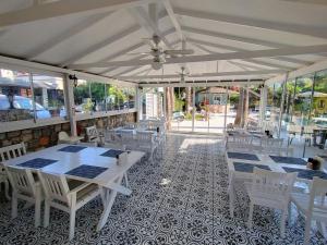 a restaurant with white tables and white chairs at Göcek Selya Hotel in Göcek