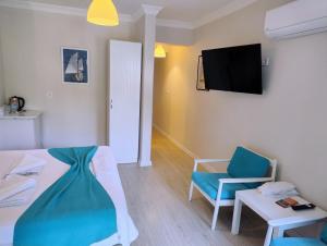 a room with a bed and a tv and a chair at Göcek Selya Hotel in Göcek