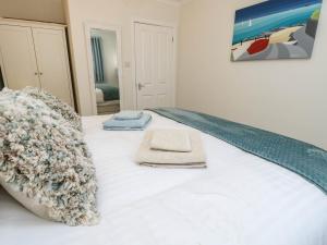 a bed with two towels sitting on top of it at The Old Post Office in Ventnor