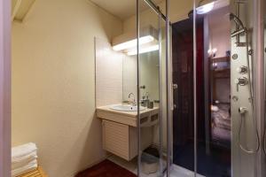 a bathroom with a sink and a shower at La Mongie Parking Petfriendly in Bagnères-de-Bigorre