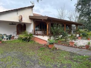a house with a porch with plants in front of it at Camping Almoetia in Calatabiano