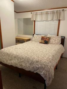 a bedroom with a large bed with a white comforter at Meadowview in Klamath