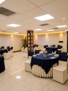 a banquet hall with blue tables and white chairs at Hotel Cymbal -Sector 31 Gurgaon in Gurgaon
