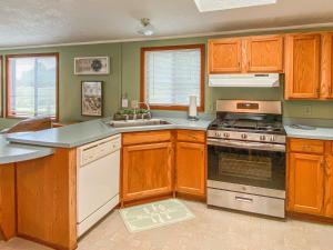 a kitchen with wooden cabinets and a stove top oven at Meadowview in Klamath +6 photos