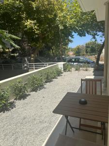 a wooden table and a bench on a patio at Rodos Suites on the Park in Rhodes Town