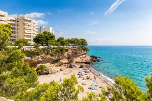 a beach with people on the sand and the ocean at Pino Alto Villa Jazmin in Miami Platja