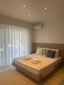 a bedroom with a large bed with two towels on it at Rodos Suites on the Park in Rhodes Town
