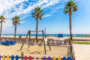 a playground at the beach with palm trees at Pino Alto Villa Jazmin in Miami Platja
