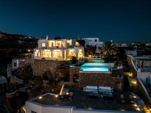 a villa with a swimming pool at night at Eagles Nest Mykonos Suites & Apartments - Shared Pool & Jacuzzis in Mikonos