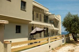 a house with an umbrella on the side of it at Green Hill Thassos in Skala Potamias