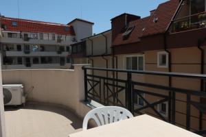 a balcony with a table and chairs and a building at goldenseaview in Pomorie