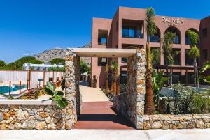 a building with palm trees in front of it at Palmea Suites in Pefki