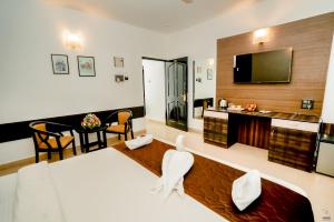 a hotel room with a bed and a flat screen tv at The Mint Calangute in Calangute