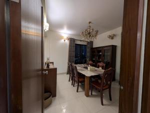 a dining room with a table and chairs and a chandelier at Family's penthouse in Dhaka