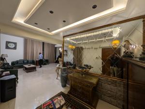 a living room with a large mirror and a man in the background at Family's penthouse in Dhaka