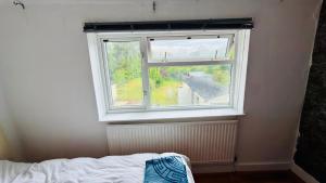 a window in a room with a bed in front of it at Welcome Homes! Feels Homes ! in Kidlington +9 photos