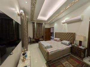 a bedroom with a bed and a table and a mirror at Family's penthouse in Dhaka +8 photos