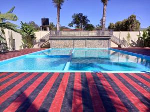 a swimming pool in a villa with palm trees at Lush Garden Hotel in Arusha