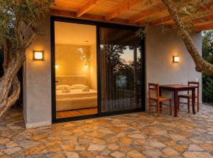 a house with a glass door with a table and a couch at Olive garden private Suite in Ksamil