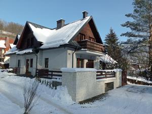 a house with a snow covered roof in the snow at Willa 4 Pory Roku in Kazimierz Dolny
