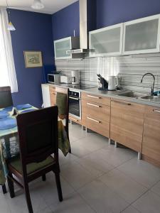 a kitchen with wooden cabinets and a sink and a table at Classic Car Museum Apartment in Riga