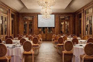 a conference room with tables and chairs and a projection screen at Fawsley Hall Hotel in Daventry +81 photos