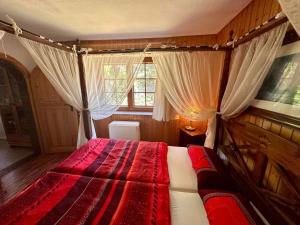 a bedroom with a red bed with curtains and a window at In Benz da brennt's in Benz +14 photos