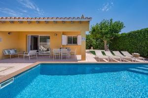 a villa with a swimming pool and a patio at Villa Aries by 3VILLAS in Cala en Forcat