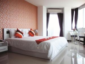 a bedroom with a large bed with orange walls at Grand Residence Jomtien in Jomtien Beach