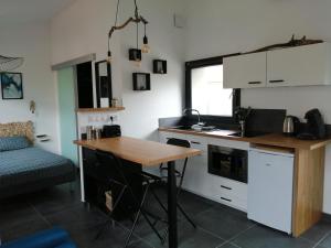 a kitchen with a wooden table in a room at Micro Maison indépendante in Commelle-Vernay