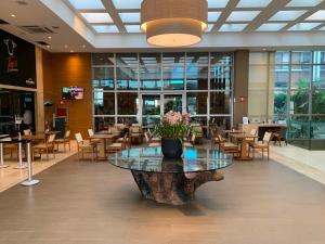 a lobby with a table with flowers on it at Flat Sofisticado no Jade Hotel Home Office in Brasília