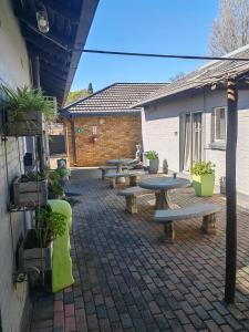 a group of picnic tables on a brick patio at Feathers Guest House in Welkom