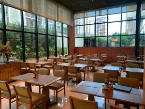 a restaurant with tables and chairs and large windows at Flat Sofisticado no Jade Hotel Home Office in Brasília