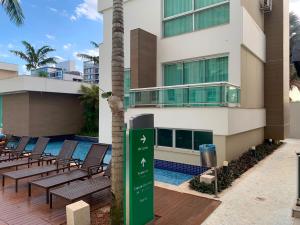 a sign in front of a building with chairs and a pool at Flat Sofisticado no Jade Hotel Home Office in Brasília