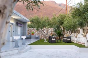 a courtyard with trees and a house with a mountain at Mani Spot Casa Elia in Areopoli