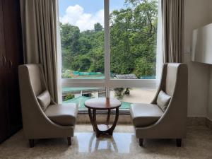 two chairs and a table in front of a large window at Lotus Villa in Phuntsholing