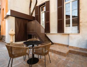 a patio with a table and chairs next to a building at Limehome Rome Trastevere in Rome