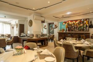 a restaurant with tables and chairs and a bar at Lotus Villa in Phuntsholing