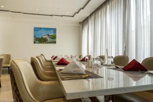 a dining room with a long table and chairs at Lotus Villa in Phuntsholing +56 photos