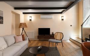 a living room with a couch and a tv at Limehome Rome Trastevere in Rome