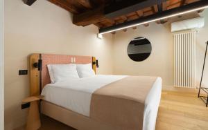 a bedroom with a large bed with a wooden headboard at Limehome Rome Trastevere in Rome