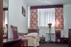 a bedroom with a bed and two chairs and a window at Hostel Evotel in Zielonka
