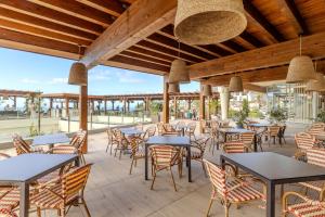 a restaurant with tables and chairs on a patio at Pestana Carlton Madeira Ocean Resort Hotel in Funchal