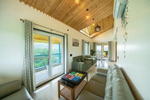 a living room with a couch and a large window at Earth by The StayCationer in Dehradun
