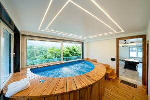 a large swimming pool in a room with a large window at Earth by The StayCationer in Dehradun