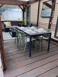 a black table and chairs on a wooden deck at Zeester 91 in Scherpenisse