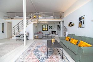 a living room with a green couch and a table at Villa Taxiarchis by Corfuescapes in Benitses